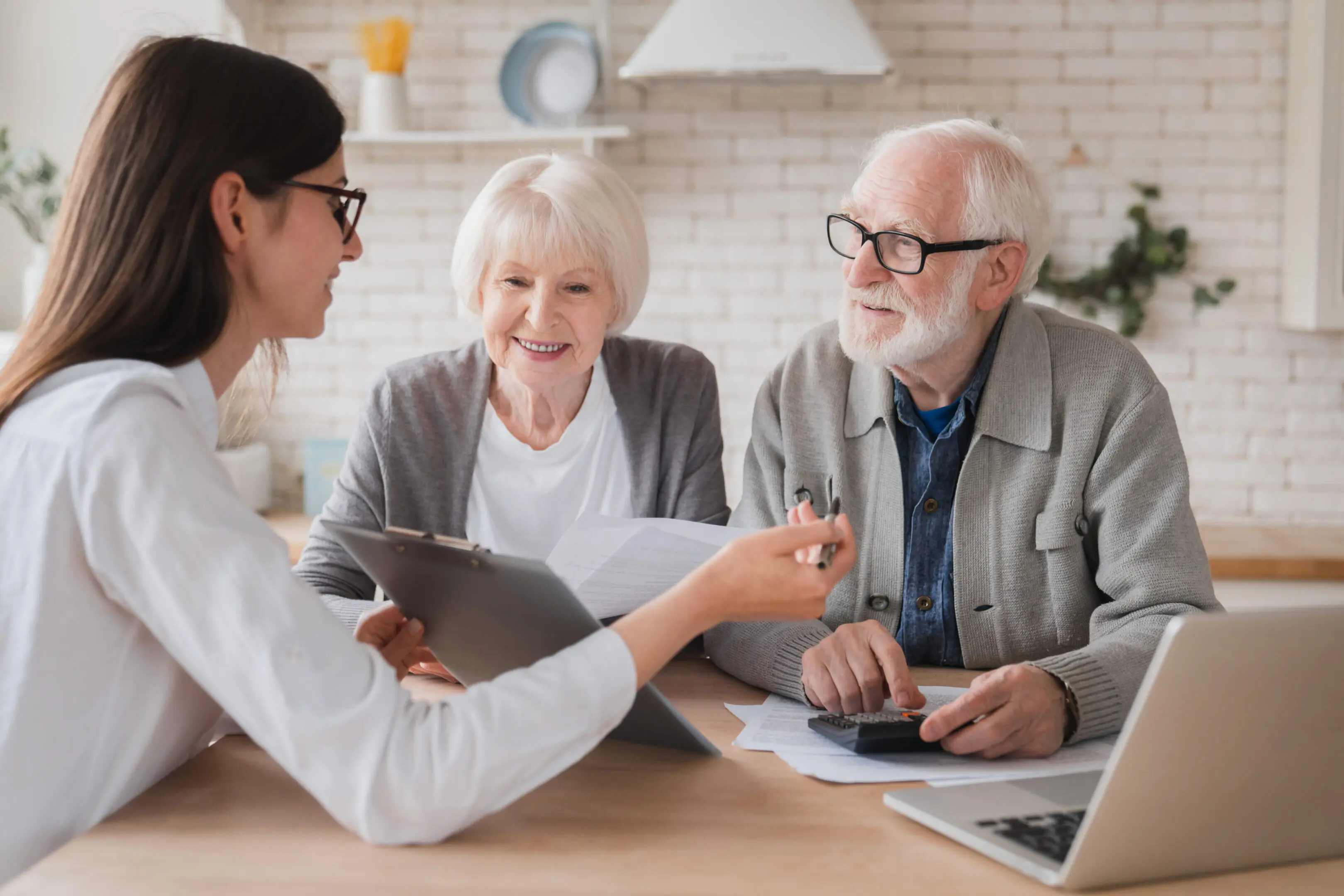 Young woman advising elderly couple with documents.